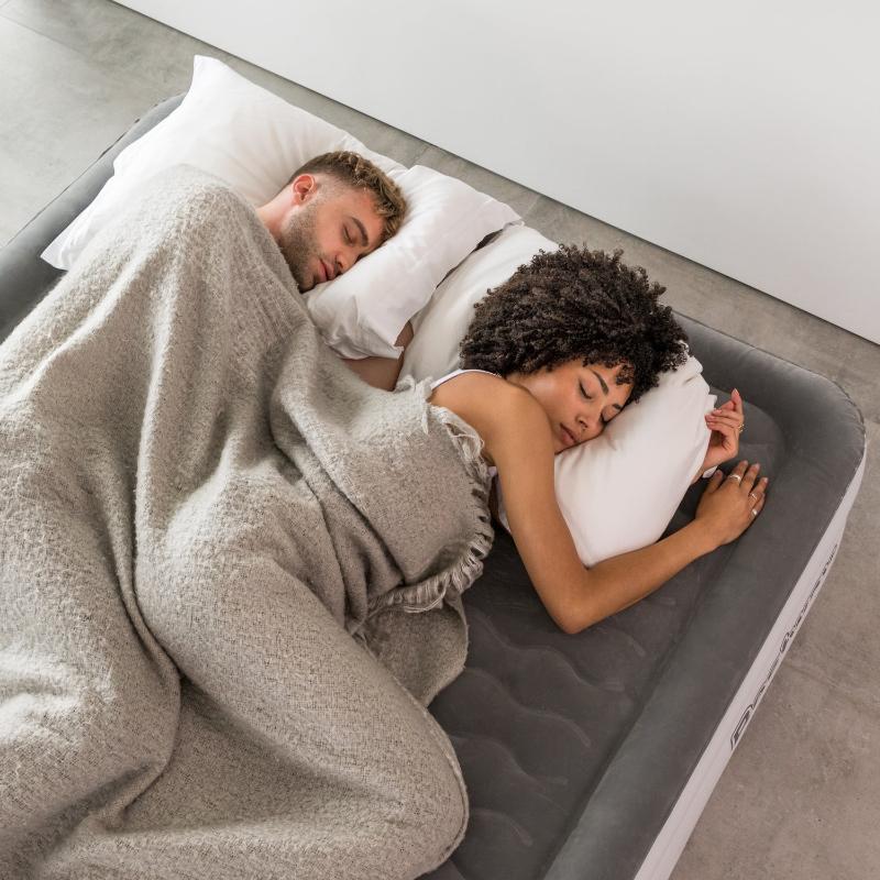 A man and woman cosily asleep on a Bestway inflatable air mattress