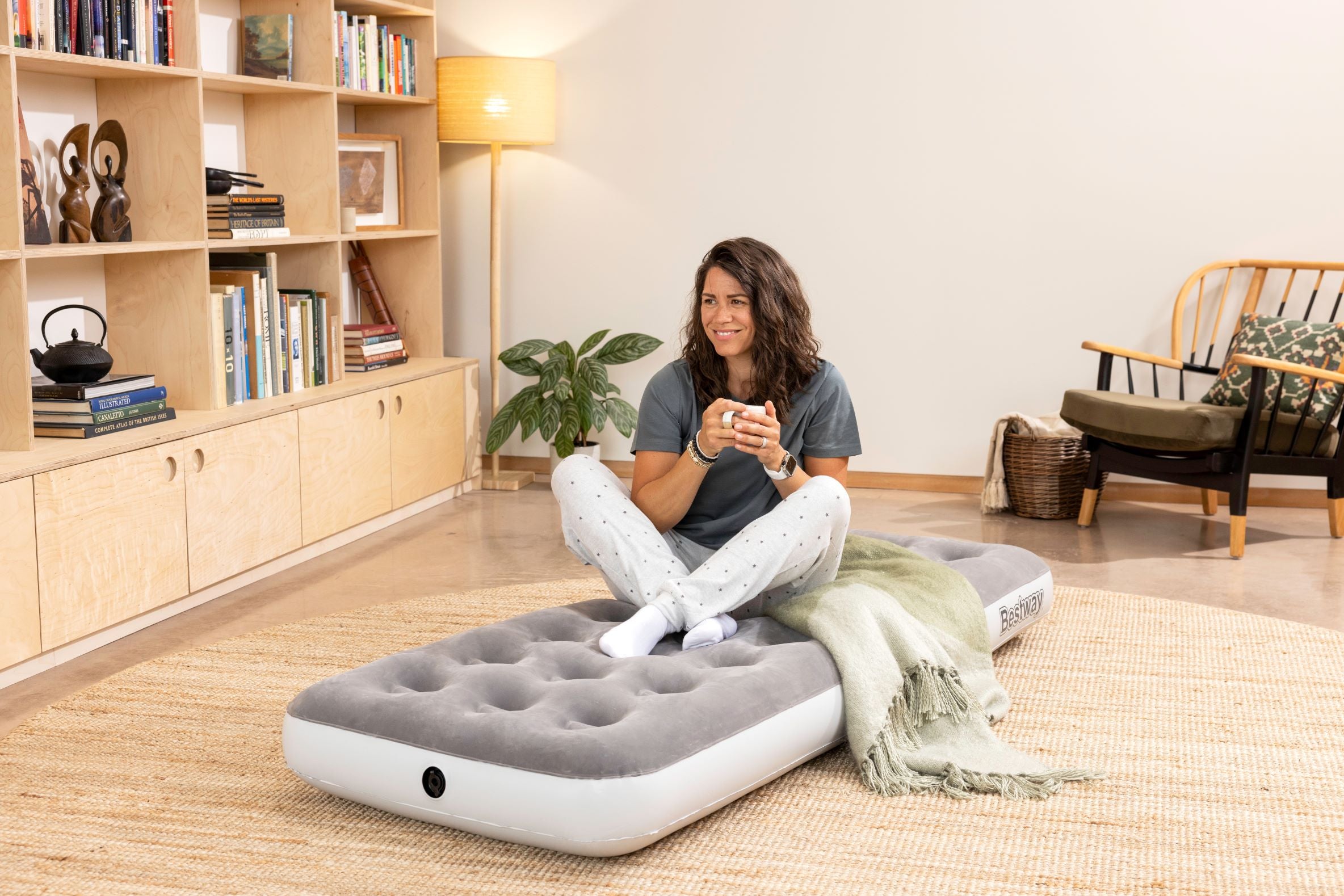 lady_sat_on_bestway_airbed_smiling_and_holding_mug